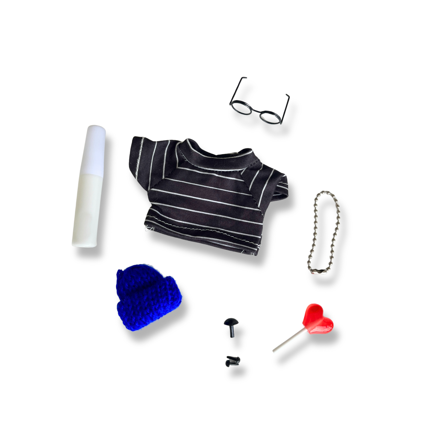 Collection of small items including a striped shirt, beanie, glasses, lollipop, and accessories on a white background